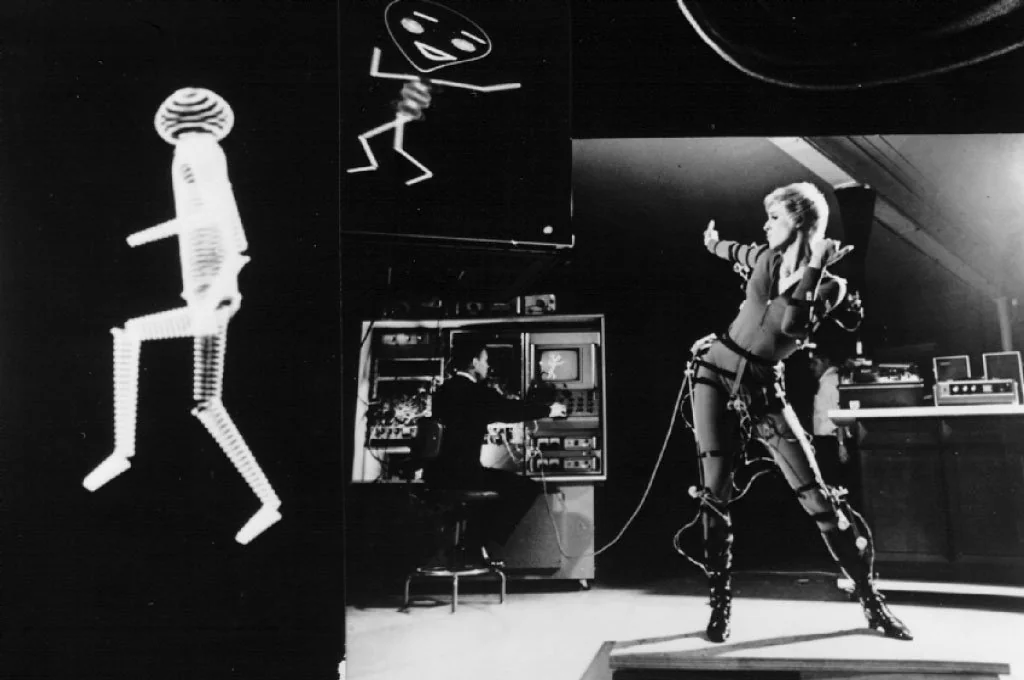 ↑ [ANIMAC / SCANIMATE ↗](https://ohiostate.pressbooks.pub/graphicshistory/chapter/12-2-animac-scanimate/) early mocap systems. Note the woman in harness vs the engineer in suit and control.
